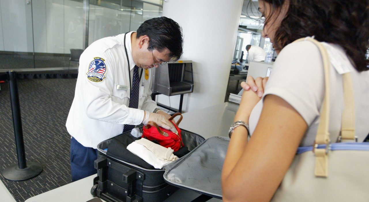 SAN FRANCISCO - AUGUST 5: A Transportation Security Administration screener inspects a bag at the international terminal of San Francisco International Airport August 5, 2003 in San Francisco, California. The TSA told screeners today to pay close attention to cameras, laptop computers and cell phones, addressing a concern that terrorists could attempt to hide explosives in electronic devices. (Photo by Justin Sullivan/Getty Images)