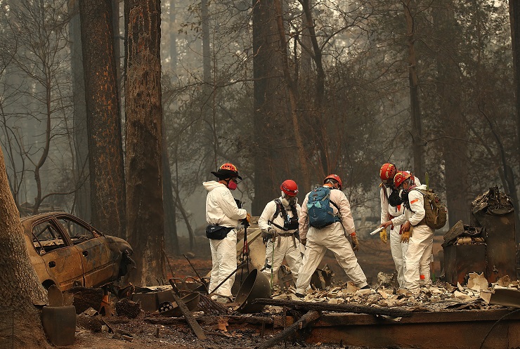 PARADISE, CA - NOVEMBER 15: Rescue workers search for human remains at a home that was burned by the Camp Fire on November 15, 2018 in Paradise, California. Fueled by high winds and low humidity the Camp Fire ripped through the town of Paradise charring over 140,000 acres, killed at least 56 people and has destroyed over 8,500 homes and businesses. The fire is currently at 40 percent containment. (Photo by Justin Sullivan/Getty Images)